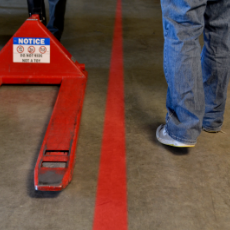 Red floor line projector next to a pallet jack